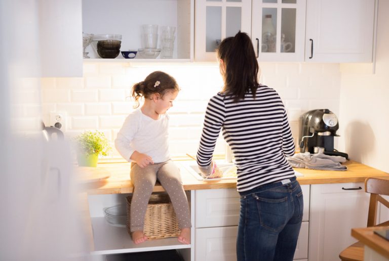 Mother with her daughter in the kitchen cooking together