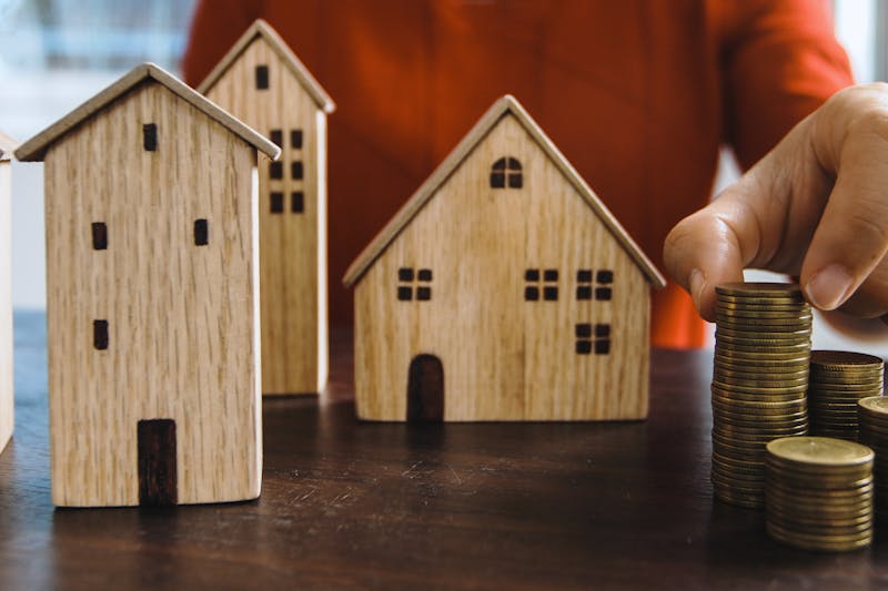 small wooden houses and a stack of coins